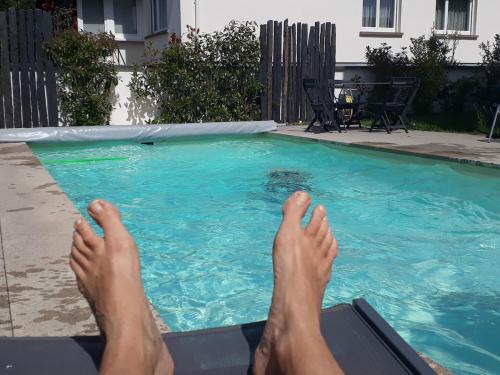 une personne posant sur un radeau dans une piscine dans l'établissement Joli studio dans maison moderne, proche de Strasbourg, à Weyersheim