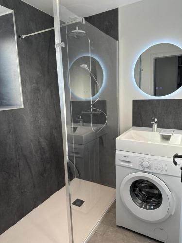 une salle de bain avec une machine à laver et un lavabo dans l'établissement Gwenn ha du, à Pleubian