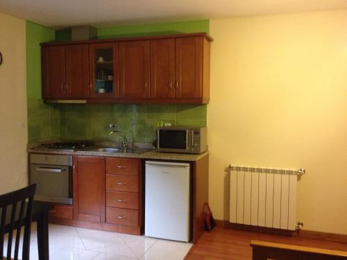 a kitchen with wooden cabinets and a white refrigerator at Casa Ribom in Geres