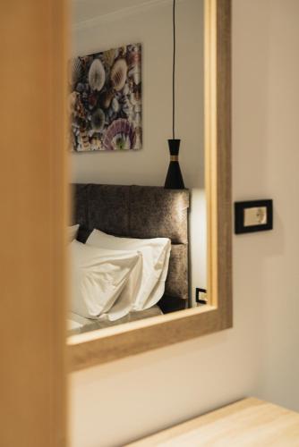 a mirror reflecting a bed in a room at Lumior Villas Lux essence by 'elite' in Zakynthos Town
