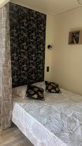 un lit avec deux oreillers dessus dans une chambre dans l'établissement Petit appartement cosy Miribel, à Miribel