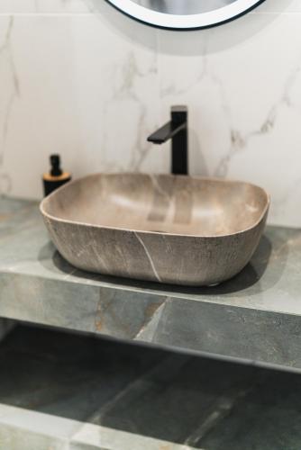 a stone sink on a counter in a bathroom at Lumior Villas Lux essence by 'elite' in Zakynthos Town
