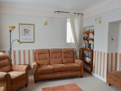 a living room with a couch and a chair at Daisy Bank Cottage in Bowness-on-Windermere