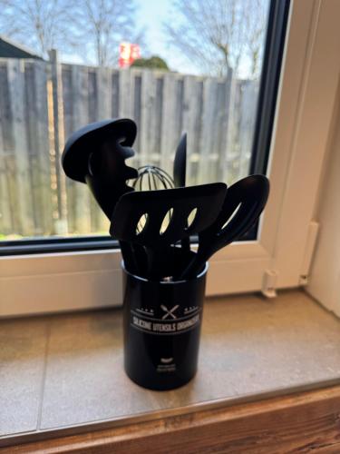 a cup full of utensils sitting in a window at Apartment Relax in Trittau