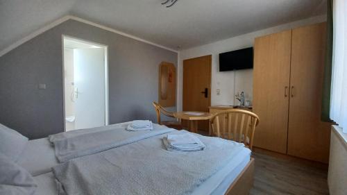 a bedroom with a bed and a table and a kitchen at Haus Waldesruh in Petersdorf