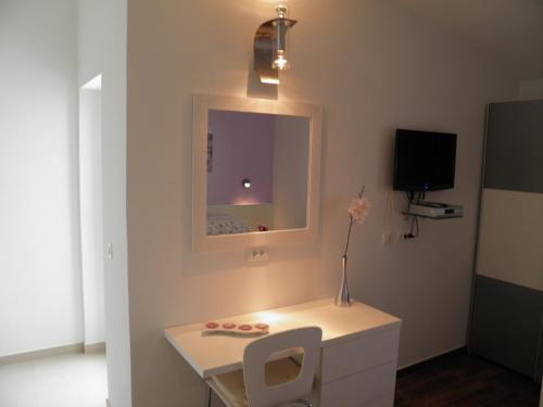 a room with a white desk and a mirror at Apartments Tomas in Primošten