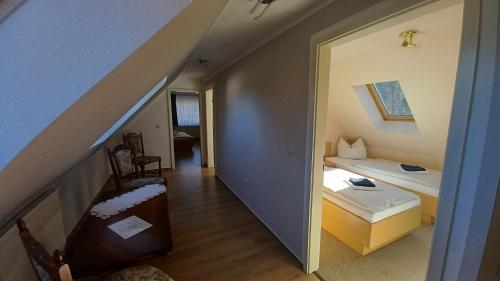 a room with a bed and a table and a staircase at Haus Waldesruh in Petersdorf