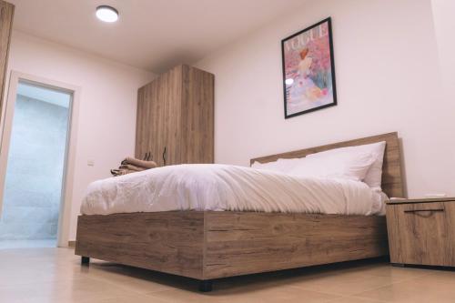 a bedroom with a wooden bed and a wooden cabinet at The Valley Collection - Suite B3 in Xagħra