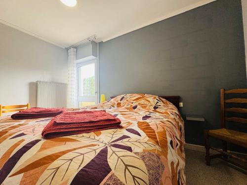 ein Schlafzimmer mit einem Bett mit einer bunten Bettdecke in der Unterkunft Cozy apartment near thermal baths in Balaruc-les-Bains