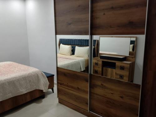 a bedroom with a mirror and a bed and a television at Old Town Grand Apart Hotel in Antalya