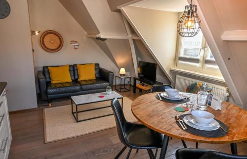 a living room with a table and a couch at Zeehuis Appartement & Studio in Zandvoort