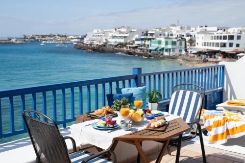 a table on a balcony with a view of the ocean at Sweet Blue in Playa Blanca