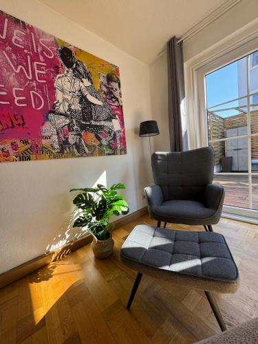 a living room with a chair and a plant at Große helle Maisonette Wohnung im Zentrum in Kassel