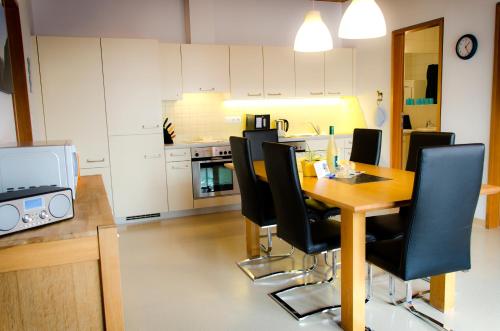 a dining room with a table and black chairs at Reiterhof Berggut Gaicht in Nesselwängle