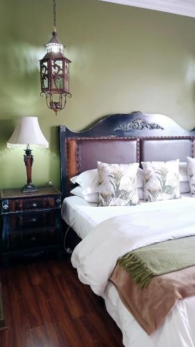 a bedroom with two beds and a lamp on a night stand at Lamon Guesthouse in Kroonstad