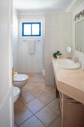 a bathroom with a toilet and a sink at Sweet Blue in Playa Blanca