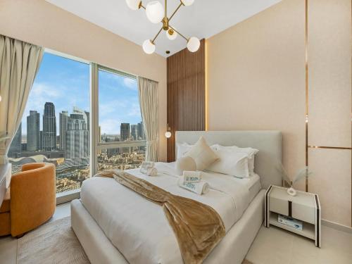 Crown Jewel 2 Bedroom Apartments I Iconic Burj Khalifa and Fountain Views I Free Parking, Gym, Pool, Wi-Fi and PS5 I by Skyline Serenity في دبي: غرفة نوم بسرير كبير مع نافذة كبيرة