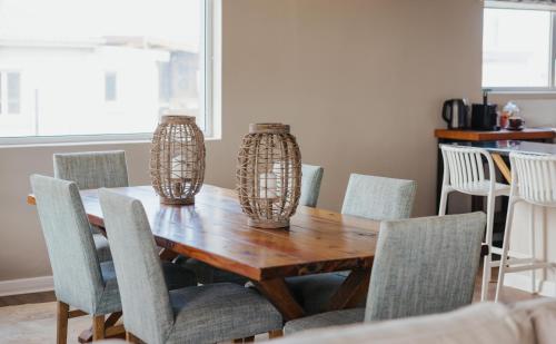 a dining room table with chairs and vases on it at Seal Point Lighthouse in Cape St Francis