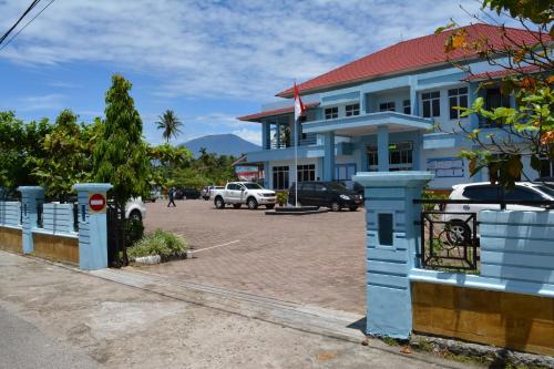 a blue building with a parking lot in front of it at Koto Hilalang Homestay in Bukittinggi