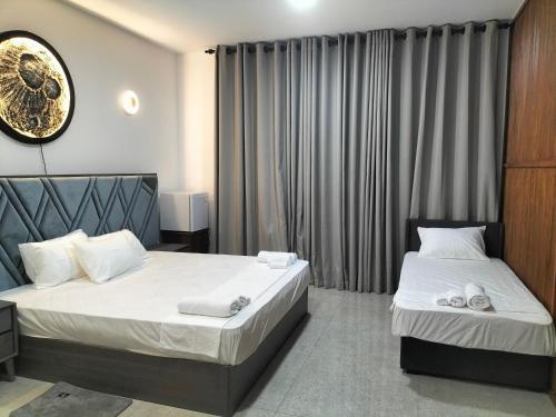 a bedroom with two beds and a clock on the wall at NN Stayz in Negombo