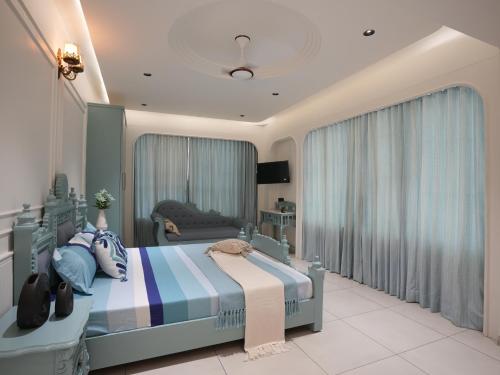 a bedroom with a bed and a television in it at The Garden Hotel in Ahmedabad