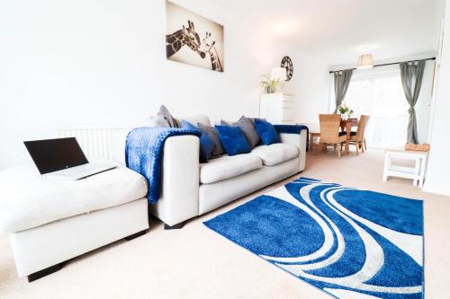 a living room with a white couch and a blue rug at Polperro House - Chic & Stylish Home in Orpington