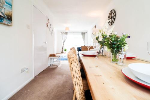 a dining room with a wooden table and chairs at Polperro House - Chic & Stylish Home in Orpington