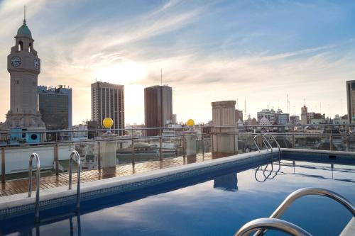 a swimming pool on the roof of a building with a clock tower at NH Collection Buenos Aires Centro Histórico in Buenos Aires