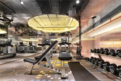 a gym with tread machines and a large chandelier at CITIGO HOUSE Tianhe Guangzhou in Guangzhou
