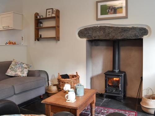 a living room with a wood stove at Coopers Cottage in Haverthwaite