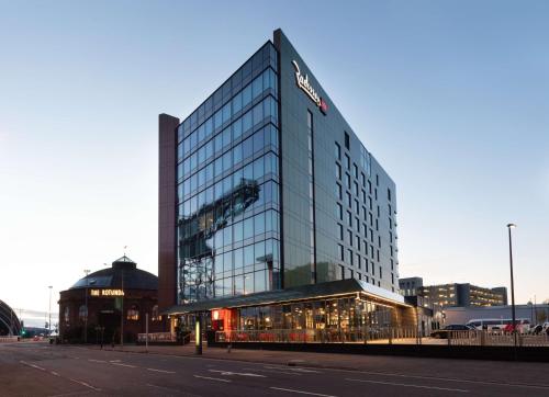a tall glass building on the side of a street at Radisson RED Hotel, Glasgow in Glasgow