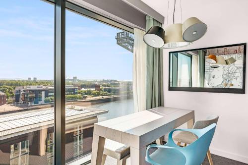 a room with a table and chairs and a large window at Radisson RED Hotel, Glasgow in Glasgow