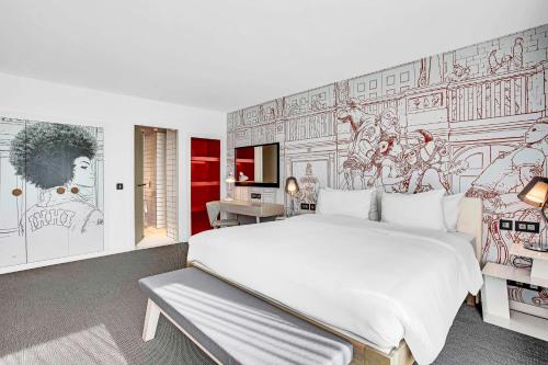 a bedroom with a large white bed and a mural at Radisson RED Hotel, Glasgow in Glasgow