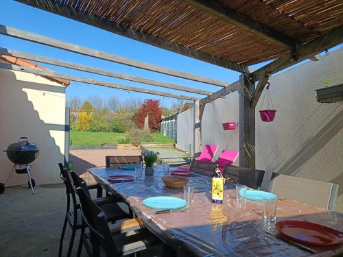 - une table avec des assiettes et des verres sur la terrasse dans l'établissement L'Ouvéa joli gîte à 10 min du parc le Puy du Fou, à Sevremont