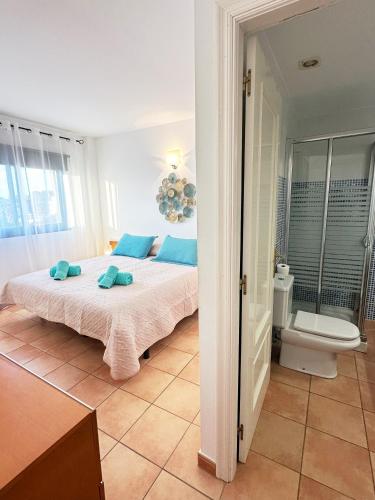 a bedroom with a bed with blue pillows on it at Can Blau Formentera Apartamento in Es Pujols