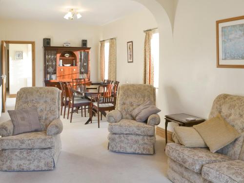 a living room with two chairs and a table at Alby Bungalow in Wetheral