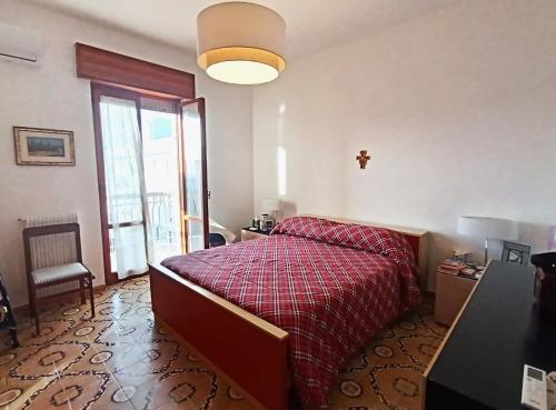 Schlafzimmer mit einem Bett mit einer roten Bettdecke in der Unterkunft Bellavista Gallipoli - Casa del Sole con box auto in Gallipoli