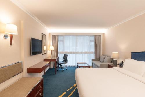 a hotel room with a large bed and a desk at Holiday Inn Golden Mile by IHG in Hong Kong
