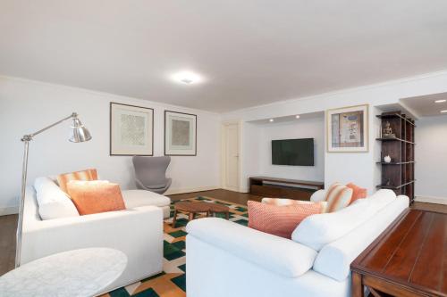a living room with two white couches and a tv at Holiday Inn Golden Mile by IHG in Hong Kong