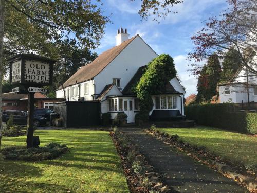 a white house with a sign in front of it at Old Farm Hotel in Birmingham