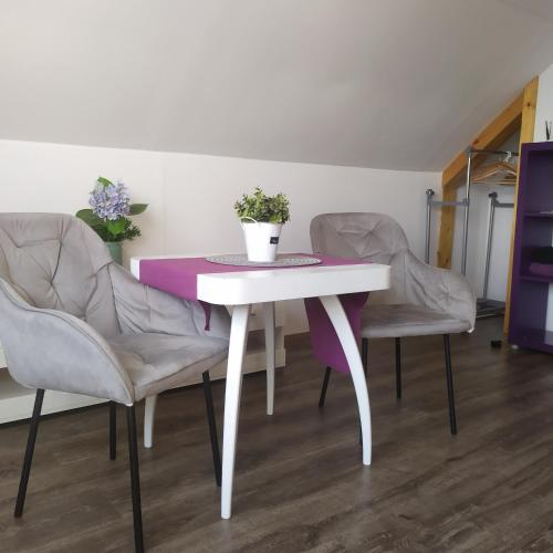 a white table with two chairs and a purple table at Magical apartment Dobříš in Dobříš