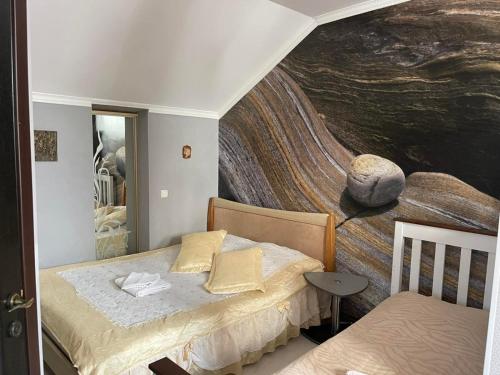 a bedroom with a large painting on the wall at Hotel Domashnii in Zhytomyr