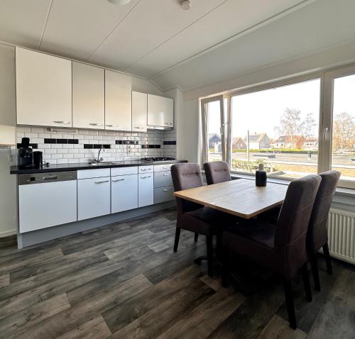 a kitchen with white cabinets and a wooden table at Hotel Brasserie Smits in Wemeldinge