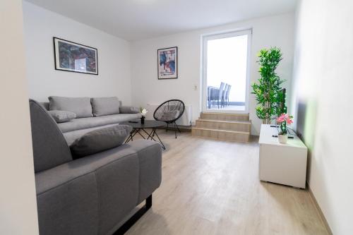 a living room with a couch and a table at Fewomo, Mosel Maisonette, mit Terrasse & Winzerflairallee, für 6 Perfekt, für 8 geeignet in Brauneberg