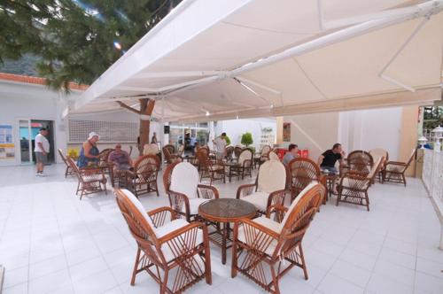 a group of people sitting at tables and chairs at Karbel Beach Hotel in Oludeniz