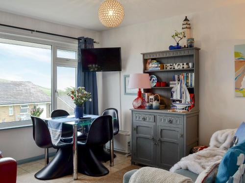 ein Wohnzimmer mit einem Tisch und einem Fenster in der Unterkunft Woolacombe Folly in Mortehoe