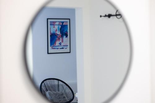 a mirror in a room with a chair and a picture at Fewomo, Mosel Maisonette, mit Terrasse & Winzerflairallee, für 6 Perfekt, für 8 geeignet in Brauneberg