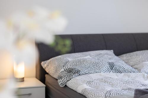 a bed with a pillow and a candle on a nightstand at Fewomo, Mosel Maisonette, mit Terrasse & Winzerflairallee, für 6 Perfekt, für 8 geeignet in Brauneberg
