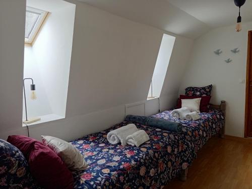 two beds in a room with two windows at Gîte 3 étoiles Le Charme Des Cerisiers 8 pers in Bouvigny-Boyeffles