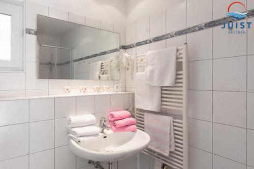a bathroom with a sink and a mirror and towels at Haus Insa 145 - Ferienwohnung elf in Juist